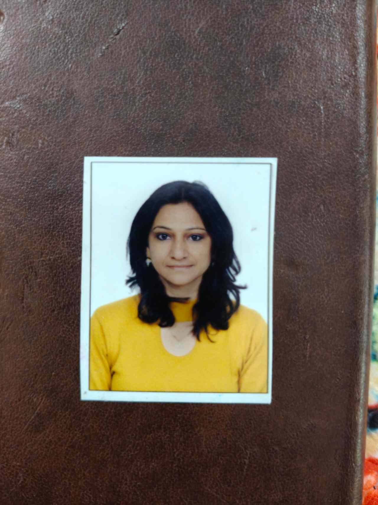 Portrait of Dr. Kapoor wearing traditional attire with academic books in background